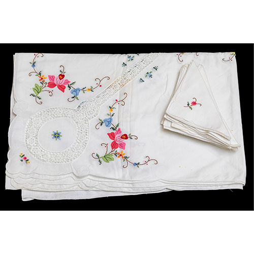 Sub.:9-On - Lote: 307 -  Mantelera en algodn con ganchillo y decoracin floral. Compuesta por mantel y once servilletas. Con manchas y una falta.