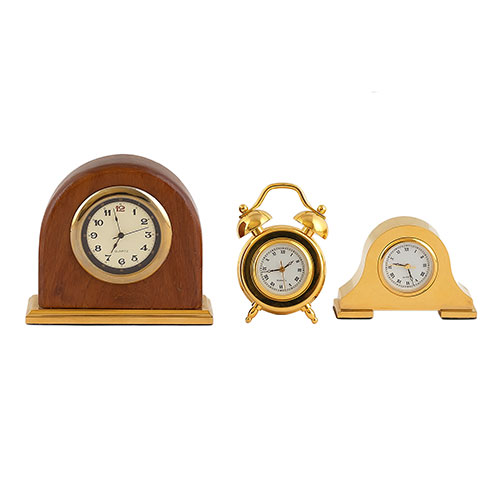 Sub.:9-On - Lote: 338 -  Lote de tres pequeos relojes de sobremesa Quarz. Uno de ellos en madera y dos en metal dorado.