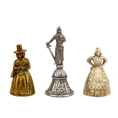 Sub.:9 - Lote: 571 -  Lote de tres campanitas en diferentes metales y con diferentes formas figurativas, dos damas y un caballero.