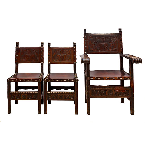 Sub.:9 - Lote: 545 -  Pareja de sillas y silln en madera tallada barnizada. Estilo neorrenacimiento, con respaldo y asiento de cuero grabado tachuelado.